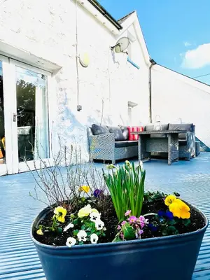 a large blue pot filled with flowers and plants at Pen Y Bont Cottage Llanuwchllyn Bala in Llanuwchllyn