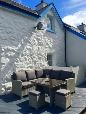 a patio with a couch and a table and a building at Pen Y Bont Cottage Llanuwchllyn Bala in Llanuwchllyn