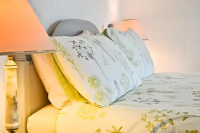 a bed with a pillow on it with a lamp at The Owls in Builth Wells