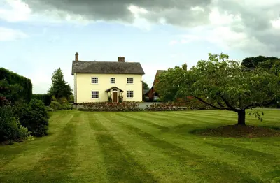 a large white house with a large grass yard at Hordley Hall in Ellesmere
