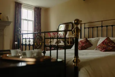 a bedroom with a bed and a table and a window at Hordley Hall in Ellesmere