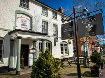 a white building with a sign in front of it at Cain Valley Hotel in Llanfyllin