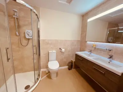 a bathroom with a toilet and a shower and a sink at Cain Valley Hotel in Llanfyllin