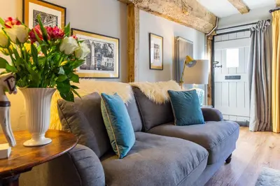 a living room with a couch and a table with flowers at Charlie's Cottage in Ludlow
