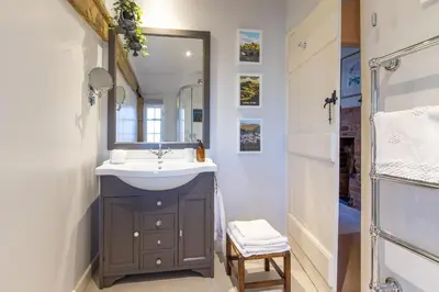 a bathroom with a sink and a mirror at Charlie's Cottage in Ludlow