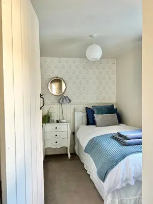 a bedroom with a bed and a mirror on the wall at Charlie's Cottage in Ludlow