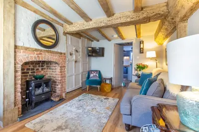 a living room with a couch and a fireplace at Charlie's Cottage in Ludlow