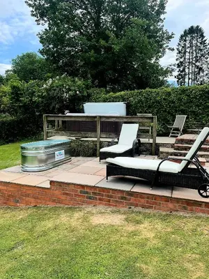a patio with two chairs and a table and a cooler at Wye Cottage in Builth Wells