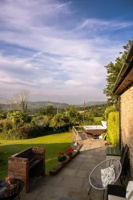 a patio with a table and chairs and a garden at Wye Cottage in Builth Wells