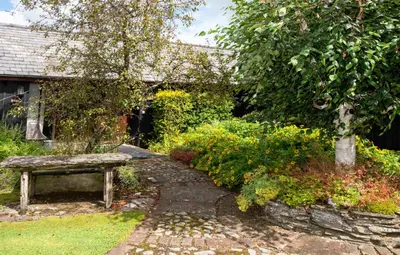 a garden with a stone path and a bench at Wye Cottage in Builth Wells