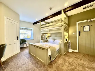 a bedroom with a bunk bed and a desk at RIVERBANC in Llangollen