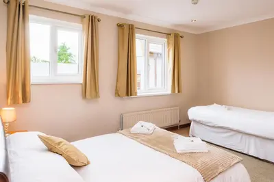two beds in a room with two windows at Elan Hotel in Rhayader
