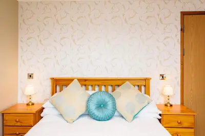 a bed with a blue pillow on top of it at Elan Hotel in Rhayader