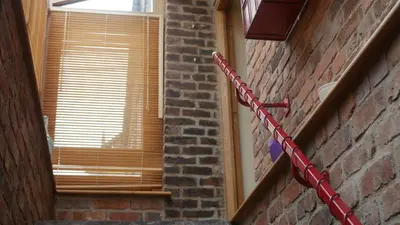 a red chain attached to a brick wall with a window at The Keep in Ludlow