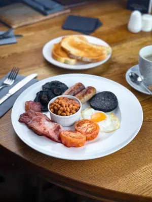a plate of breakfast food with eggs sausage beans and pancakes at The Corbet Arms in Shrewsbury
