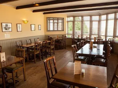 a restaurant with wooden tables and chairs in a room at The Corbet Arms in Shrewsbury