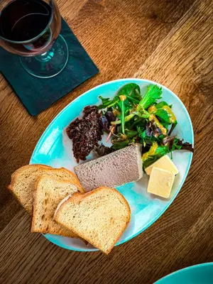 a plate of food with bread and a salad and greens at The Corbet Arms in Shrewsbury