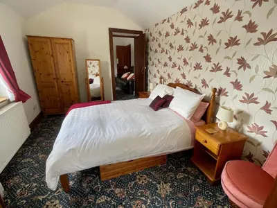 a bedroom with a bed and a chair at Plough and Harrow in Brecon