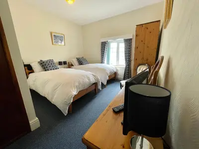 a room with two beds and a desk with a computer at Plough and Harrow in Brecon