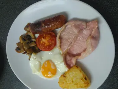a plate of breakfast food with eggs sausage and mushrooms at Plough and Harrow in Brecon