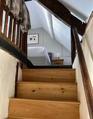 a staircase leading up to a bedroom with a bed at Number 22, Castle Street in Hay-on-Wye
