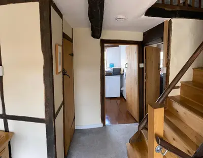 a hallway with stairs and a room with a kitchen at Number 22, Castle Street in Hay-on-Wye