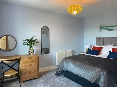 a bedroom with a bed and a desk and a mirror at Harbourmaster Hotel in Aberaeron