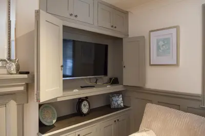 a living room with a flat screen television in a cabinet at Ludlow - Linnet House - Well Presented Townhouse With Parking - Perfect Location For Exploring On Foot, Sleeps Up To 8 Guests - Hosted by RENTMYHOUSE in Ludlow