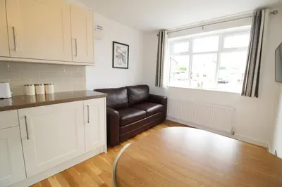 a kitchen with a leather couch and a table at The annex at 44 Belvidere Road in Shrewsbury