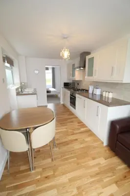a kitchen with a wooden table and a wooden floor at The annex at 44 Belvidere Road in Shrewsbury