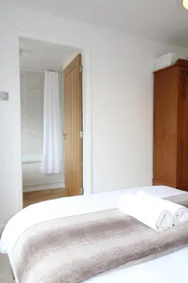 a white bedroom with a bed and a window at The annex at 44 Belvidere Road in Shrewsbury