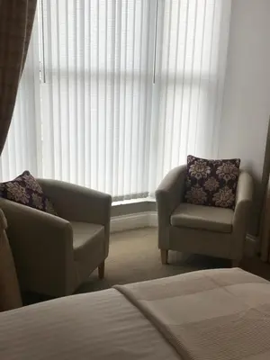 a living room with two chairs and a window at Endeavour Guest House in Barmouth