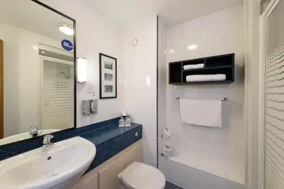 a bathroom with a sink and a toilet and a mirror at Holiday Inn Express Shrewsbury by IHG in Shrewsbury