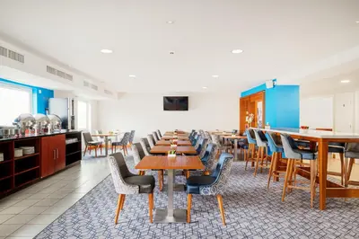 a dining room with wooden tables and chairs at Holiday Inn Express Shrewsbury by IHG in Shrewsbury