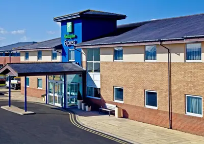 a hotel building with a bench in front of it at Holiday Inn Express Shrewsbury by IHG in Shrewsbury
