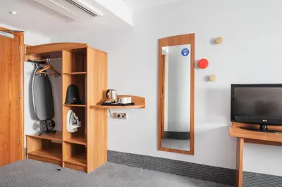a room with a tv and a mirror at Holiday Inn Express Shrewsbury by IHG in Shrewsbury
