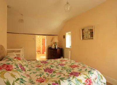 a bedroom with a large bed with a floral bedspread at Church Lane Cottage in Llanidloes