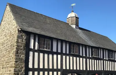 an old black and white building with a tower at Church Lane Cottage in Llanidloes