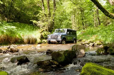 a truck driving through a stream in a forest at Llanerchindda Farm Guest House in Cynghordy