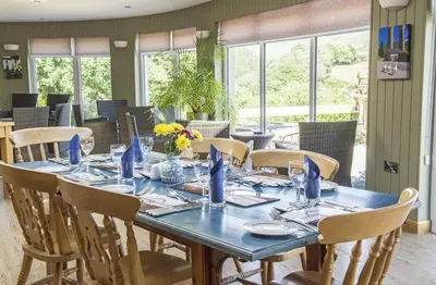 a dining room with a blue table and chairs at Llanerchindda Farm Guest House in Cynghordy
