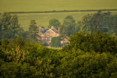 a large house in the middle of a field at Peterstone Court Country House Restaurant & Spa in Brecon