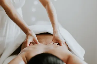 a woman laying on a bed with her hands on her face at Peterstone Court Country House Restaurant & Spa in Brecon