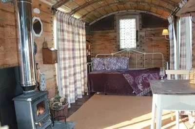 a bedroom with a bed and a wood stove at Off the Rails in Oswestry