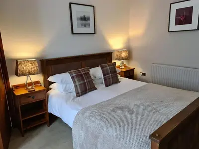 a bedroom with a bed with two night stands and two lamps at Ty Morgan's in Rhayader