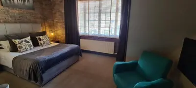 a bedroom with a bed and a blue chair at Ty Morgan's in Rhayader