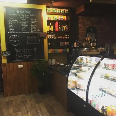 a counter in a restaurant with a menu on the wall at Ty Morgan's in Rhayader