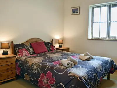a bedroom with a bed with two teddy bears on it at Ty Nant in Llanon