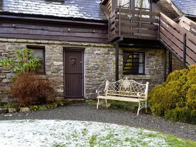 a bench sitting in front of a stone house at Kite 1 - Uk6549 in Llanfihangel-Bryn-Pabuan