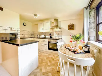 a kitchen with a table with chairs and a counter top at Kite 1 - Uk6549 in Llanfihangel-Bryn-Pabuan