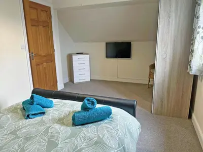 a bedroom with two blue towels on a bed at Acorn Cottage in Kingsland
